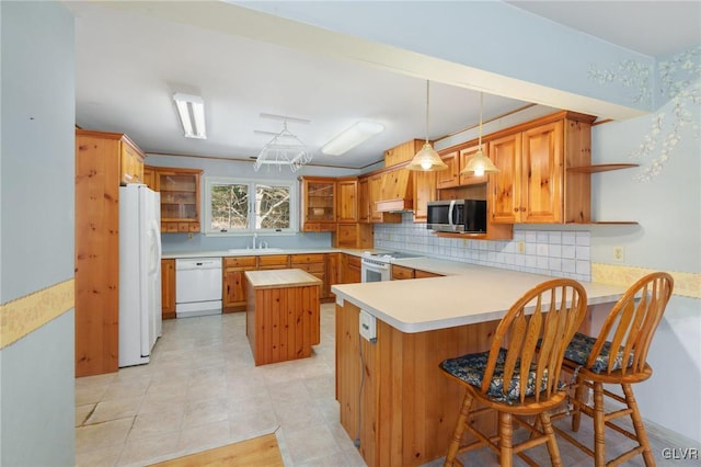 kitchen with a peninsula, white appliances, light countertops, a center island, and open shelves