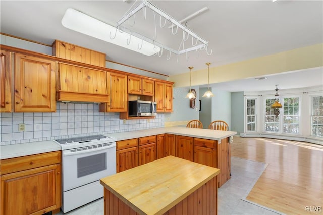 kitchen featuring a center island, pendant lighting, stainless steel microwave, and electric range