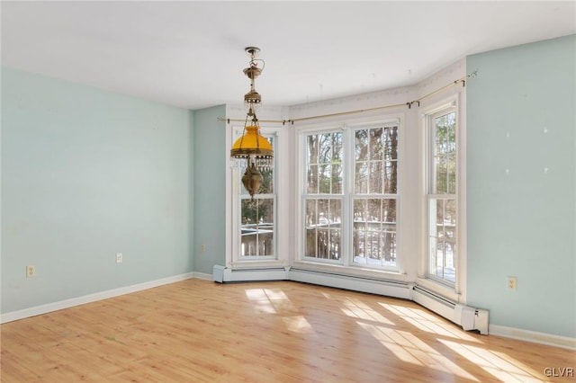 unfurnished dining area with light wood finished floors and baseboards