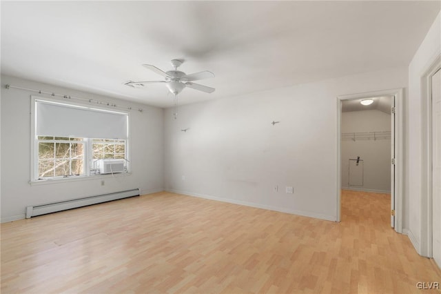 unfurnished room featuring baseboards, baseboard heating, and light wood-style floors