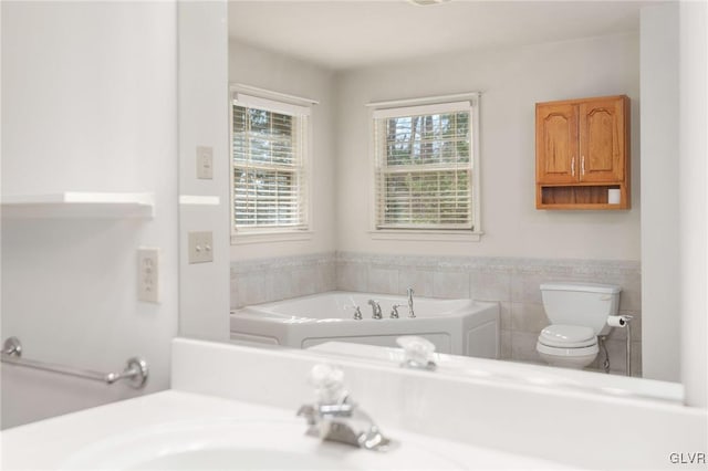 bathroom with a garden tub and toilet