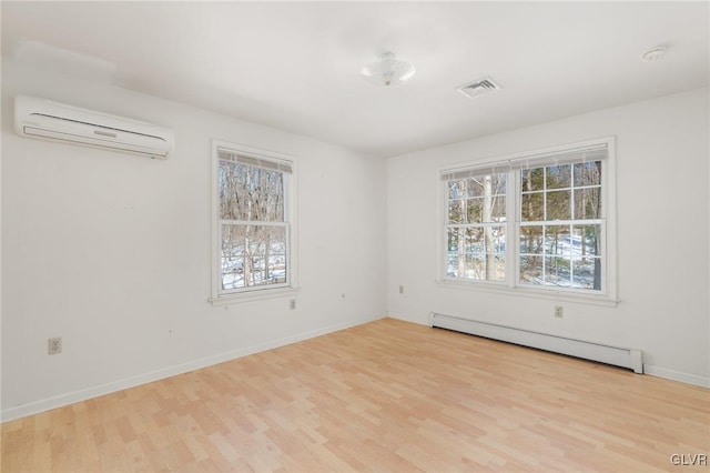 unfurnished room featuring a baseboard heating unit, visible vents, a wall mounted air conditioner, and a wealth of natural light