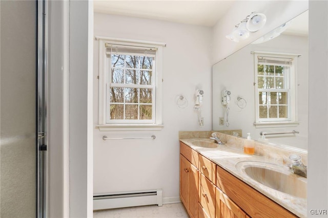 bathroom featuring a sink, baseboard heating, and double vanity