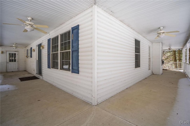 view of side of home featuring a ceiling fan and covered porch