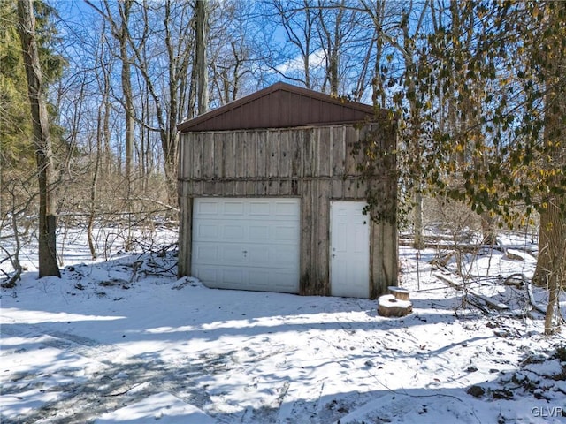 snow covered garage featuring a garage