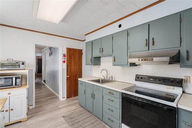 kitchen featuring range with electric stovetop, a sink, light countertops, range hood, and stainless steel microwave