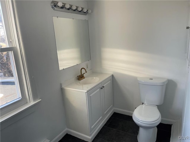 half bath with toilet, tile patterned flooring, baseboards, and vanity