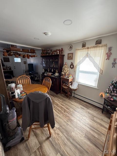 dining space featuring baseboard heating and light wood-type flooring