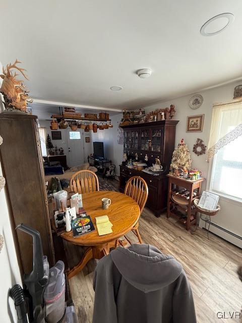 dining space with light wood-style floors and a baseboard heating unit