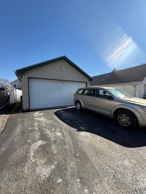 exterior space featuring a detached garage and an outbuilding