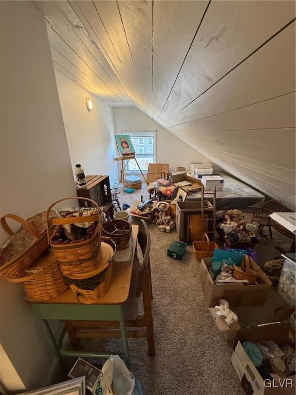 interior space featuring carpet floors, wood ceiling, and lofted ceiling