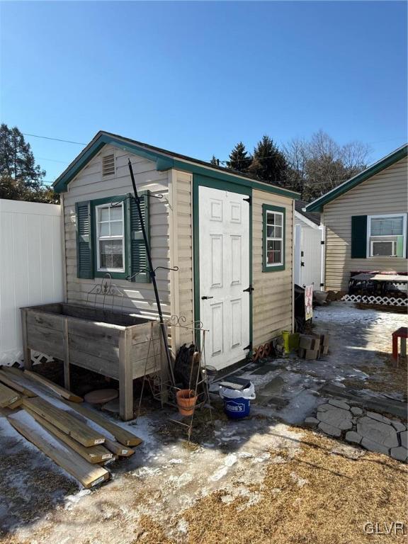 view of shed featuring fence