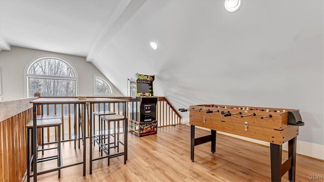 game room featuring light wood-style flooring and vaulted ceiling