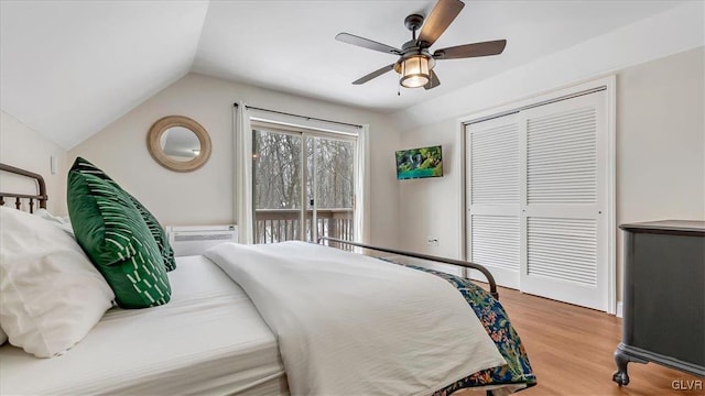 bedroom with a closet, a ceiling fan, vaulted ceiling, light wood-type flooring, and a wall mounted air conditioner