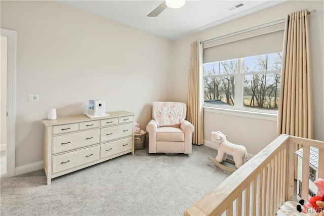 bedroom featuring a crib, baseboards, visible vents, and light colored carpet