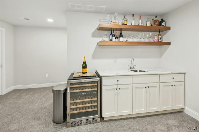 bar with light carpet, visible vents, wine cooler, indoor wet bar, and a sink