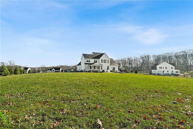 view of yard with fence and a rural view