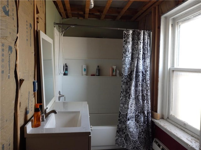 full bath featuring a baseboard heating unit, vanity, and shower / tub combo with curtain