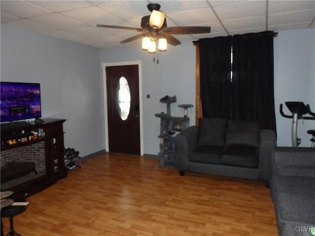 living area with a paneled ceiling, ceiling fan, and wood finished floors