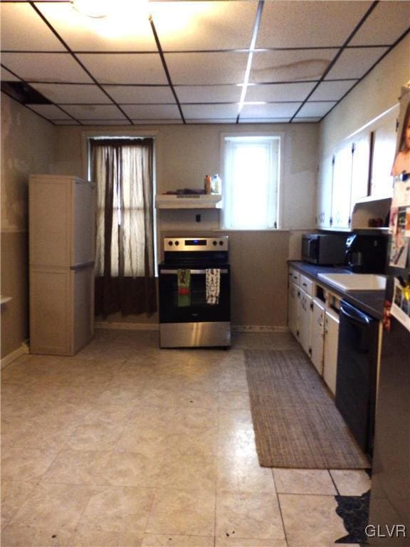 kitchen with appliances with stainless steel finishes, a paneled ceiling, and under cabinet range hood