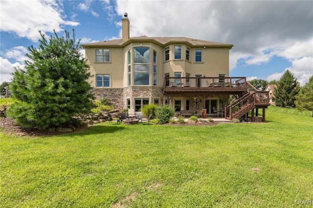 back of property featuring a deck, stone siding, a yard, stairway, and stucco siding