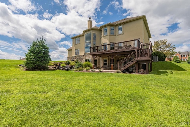 back of property with a yard, a chimney, stucco siding, stairway, and a wooden deck