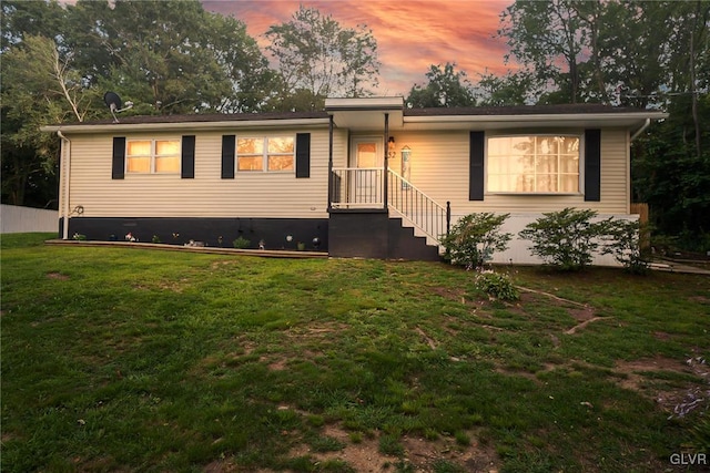 view of front of property featuring crawl space and a lawn