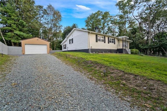 view of front facade with a detached garage, crawl space, fence, an outdoor structure, and a front lawn