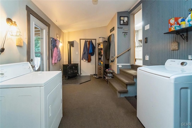 laundry area featuring laundry area, dark colored carpet, separate washer and dryer, and a wood stove