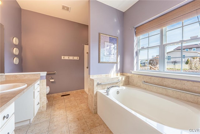 full bathroom with toilet, vanity, visible vents, a bath, and tile patterned floors