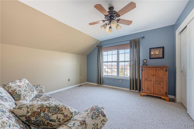 sitting room featuring lofted ceiling, baseboards, a ceiling fan, and light colored carpet