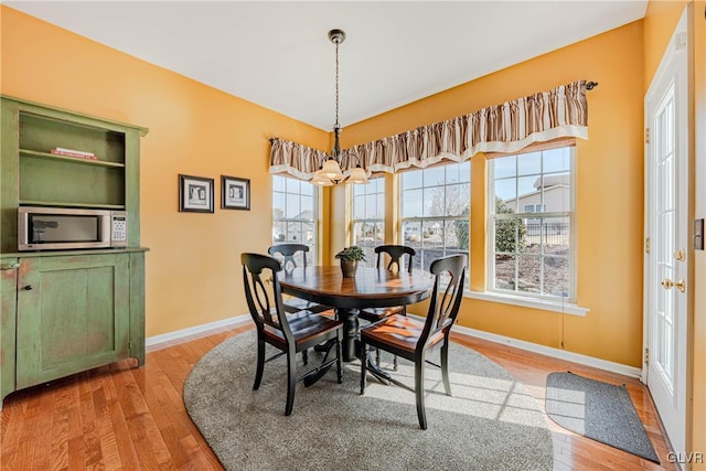 dining space featuring a chandelier, plenty of natural light, and wood finished floors