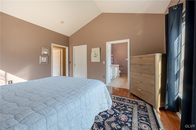 bedroom with vaulted ceiling and light wood-style flooring