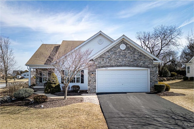 view of front of property with stone siding, aphalt driveway, a front lawn, and an attached garage