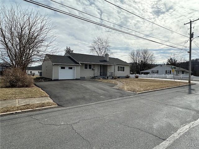 view of front of home with driveway, a chimney, a garage, and fence