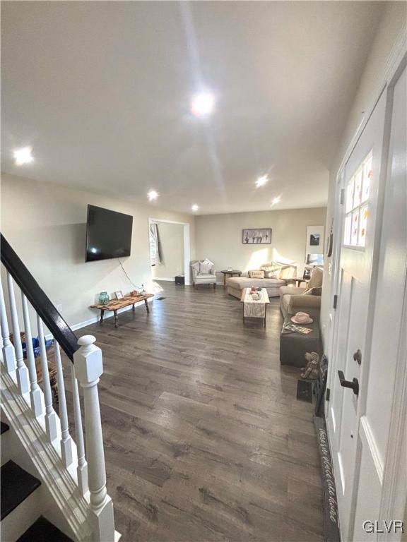 living room featuring stairway, dark wood-type flooring, and recessed lighting