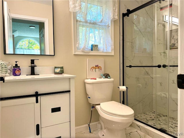 bathroom with a marble finish shower, baseboards, toilet, marble finish floor, and vanity