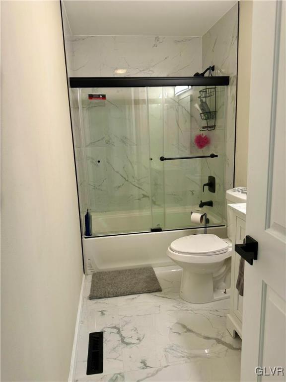 full bath featuring toilet, marble finish floor, combined bath / shower with glass door, and vanity