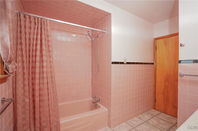 bathroom with a wainscoted wall, tile patterned flooring, shower / bath combo with shower curtain, and tile walls