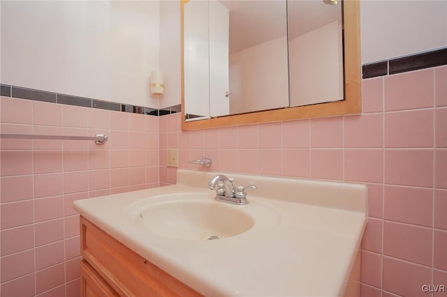 bathroom featuring vanity and tile walls