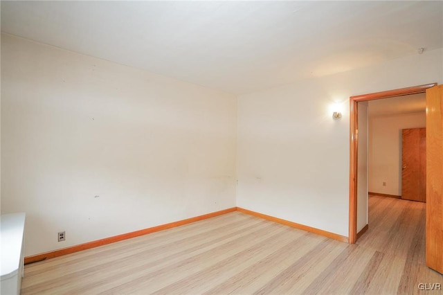 empty room featuring light wood-style floors and baseboards