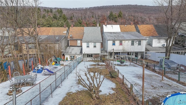 back of house with fence and a wooded view