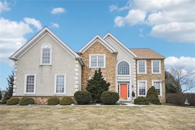 view of front of house featuring stone siding, a front lawn, and stucco siding