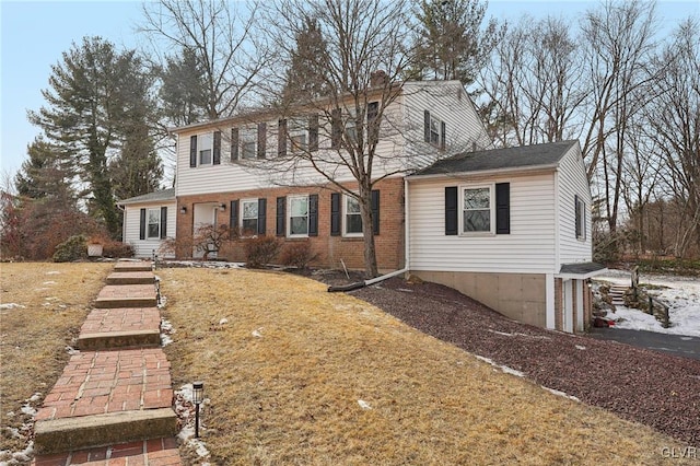 colonial house with brick siding and a front lawn