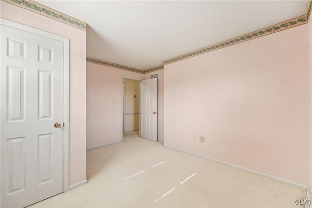 unfurnished bedroom featuring light colored carpet and baseboards