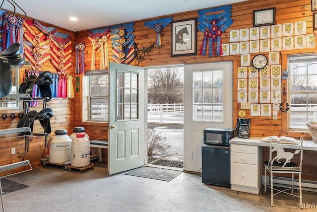 interior space featuring tile patterned floors, baseboard heating, and wooden walls