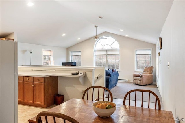 dining area with a ceiling fan, lofted ceiling, recessed lighting, a baseboard heating unit, and light colored carpet