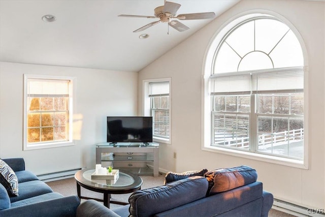 living area featuring a baseboard heating unit, a ceiling fan, and a wealth of natural light