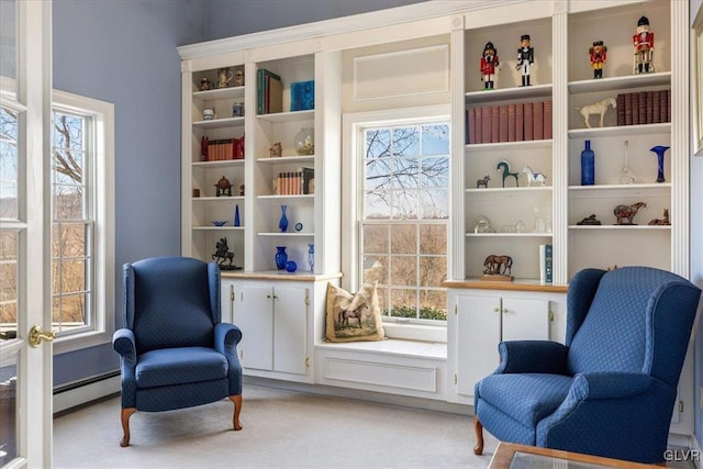 sitting room with a baseboard radiator, light colored carpet, and a healthy amount of sunlight