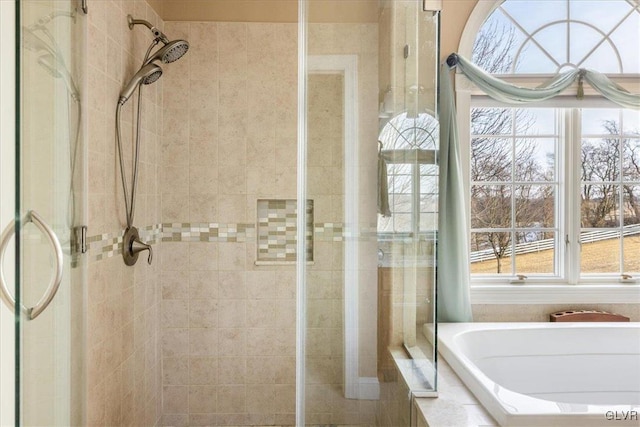 bathroom with a stall shower and a garden tub